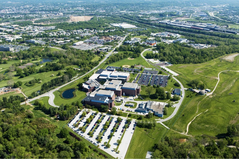 aerial view of buildings, parking lots and greenery