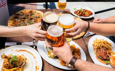 people eating dinner and cheers with beer glasses