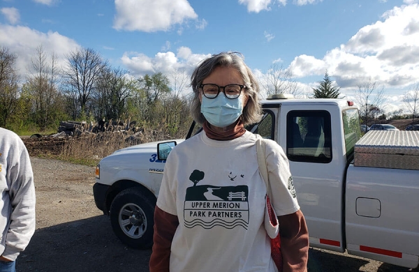 woman with face mask standing in front of a truck