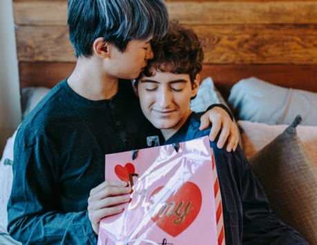 person holding a gift bag and hugging another person