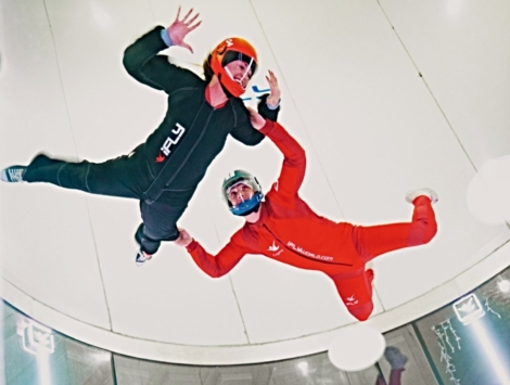 two people in the wind tunnel at an indoor skydiving facility