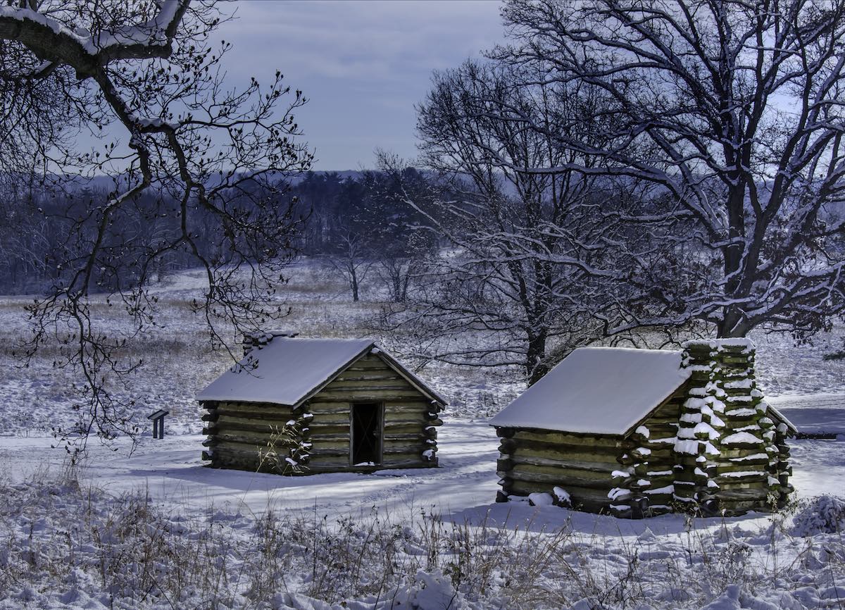 two log cabins outdoored covered in snow